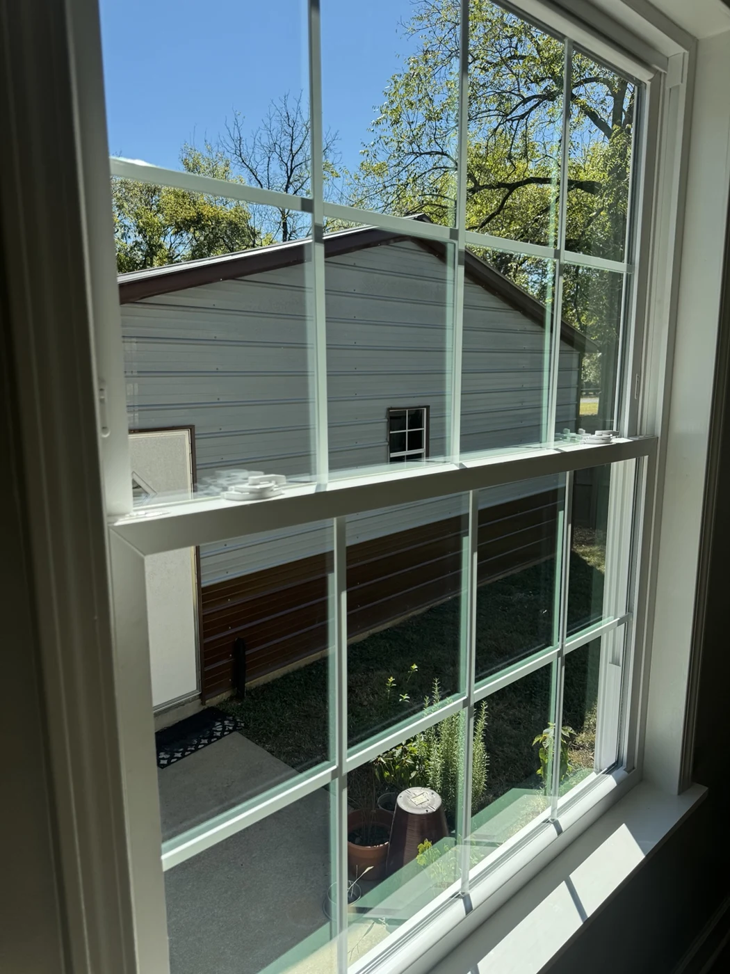 After cleaning: clearer residential window glass looking toward the same neighboring building